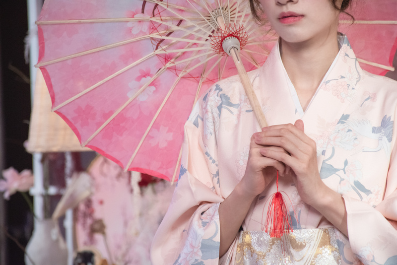 Woman in Floral Kimono Holding a Traditional Paper Umbrella